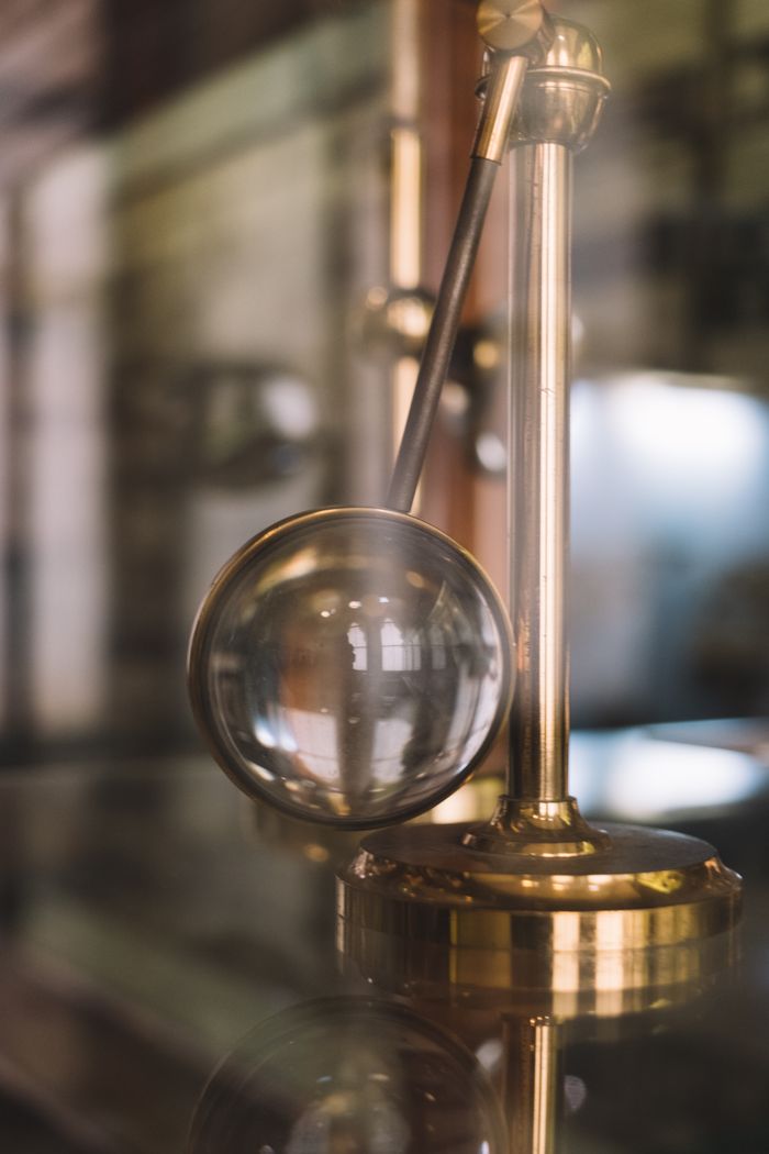An antique brass magnifier standing on a polished bench, photo by Ellie Burgin on Pexels