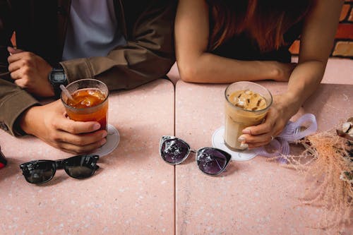 Close-Up Shot of Two People Holding Their Beverages