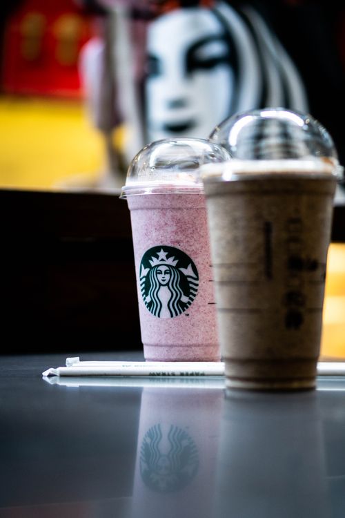 Free Close-up of two Starbucks frappuccinos in a modern café with artistic background. Stock Photo