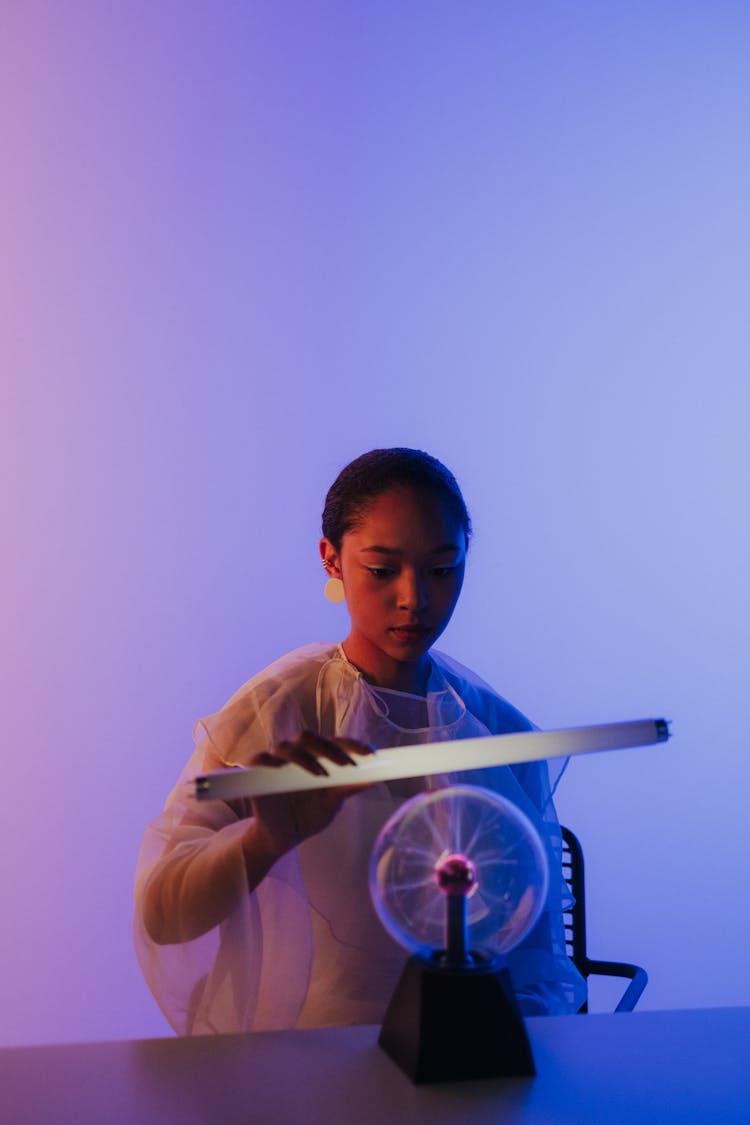 Woman Experimenting With Magnetic Ball On Table