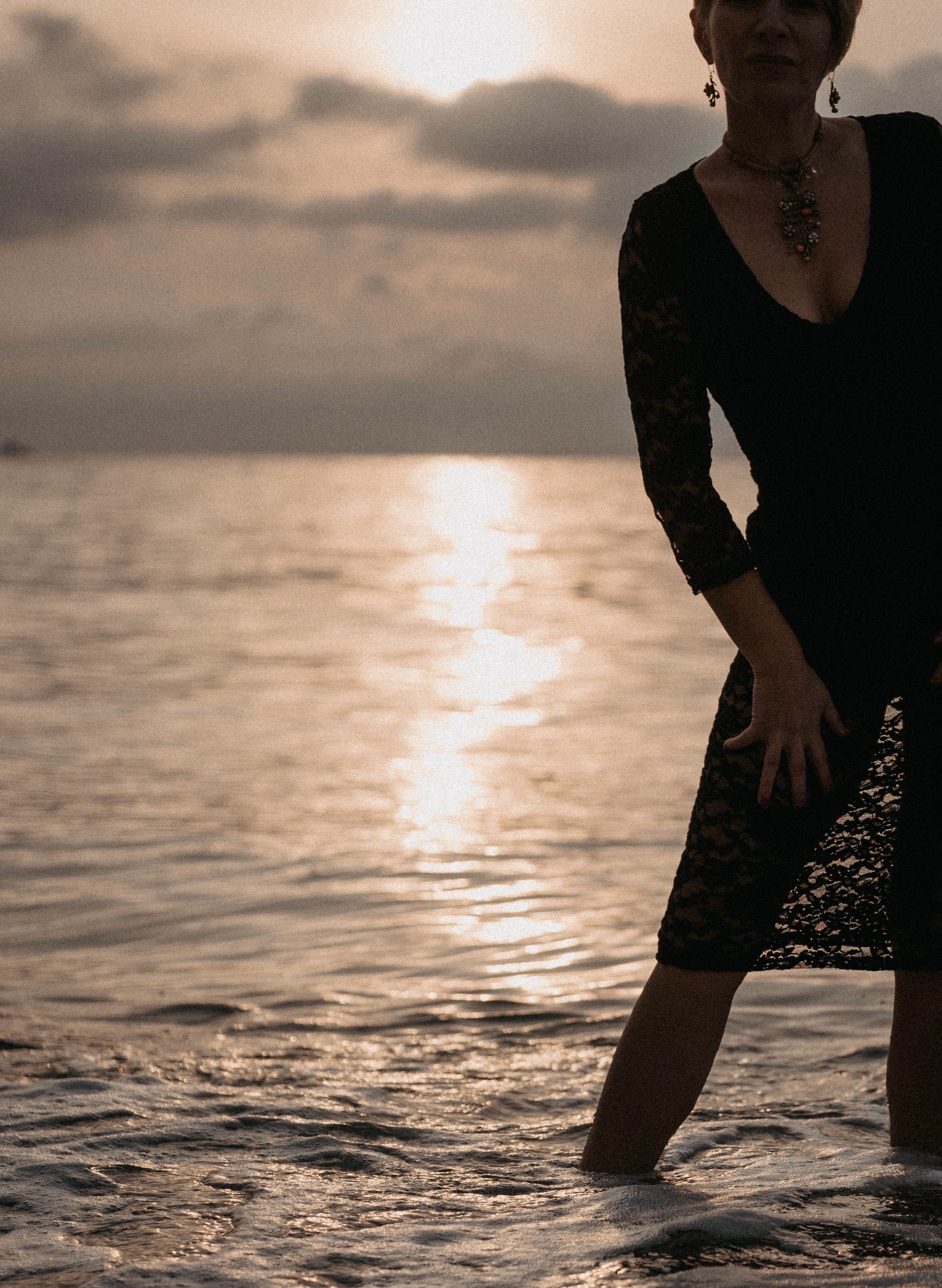 Woman in Black Dress Kicking the Water  Free Stock Photo