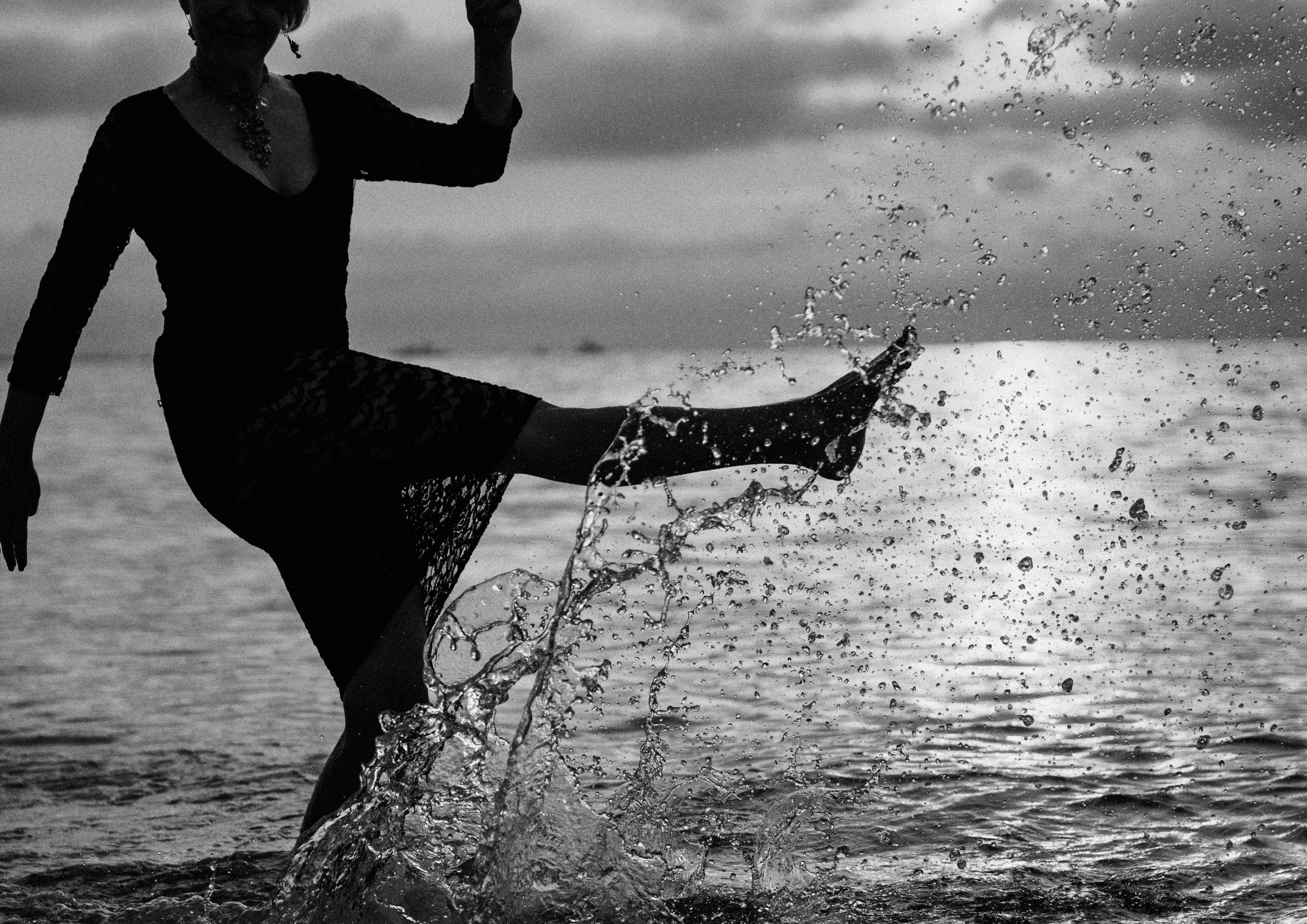 Woman in Black Dress Kicking the Water Free Stock Photo Woman in Black Dress Kicking the Water Free Stock Photo