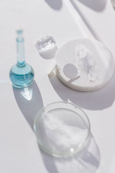 Glassware on a white surface casting shadows, ideal for scientific themes.