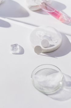 Close-up of laboratory equipment on white background with petri dish and flasks, depicting scientific research.