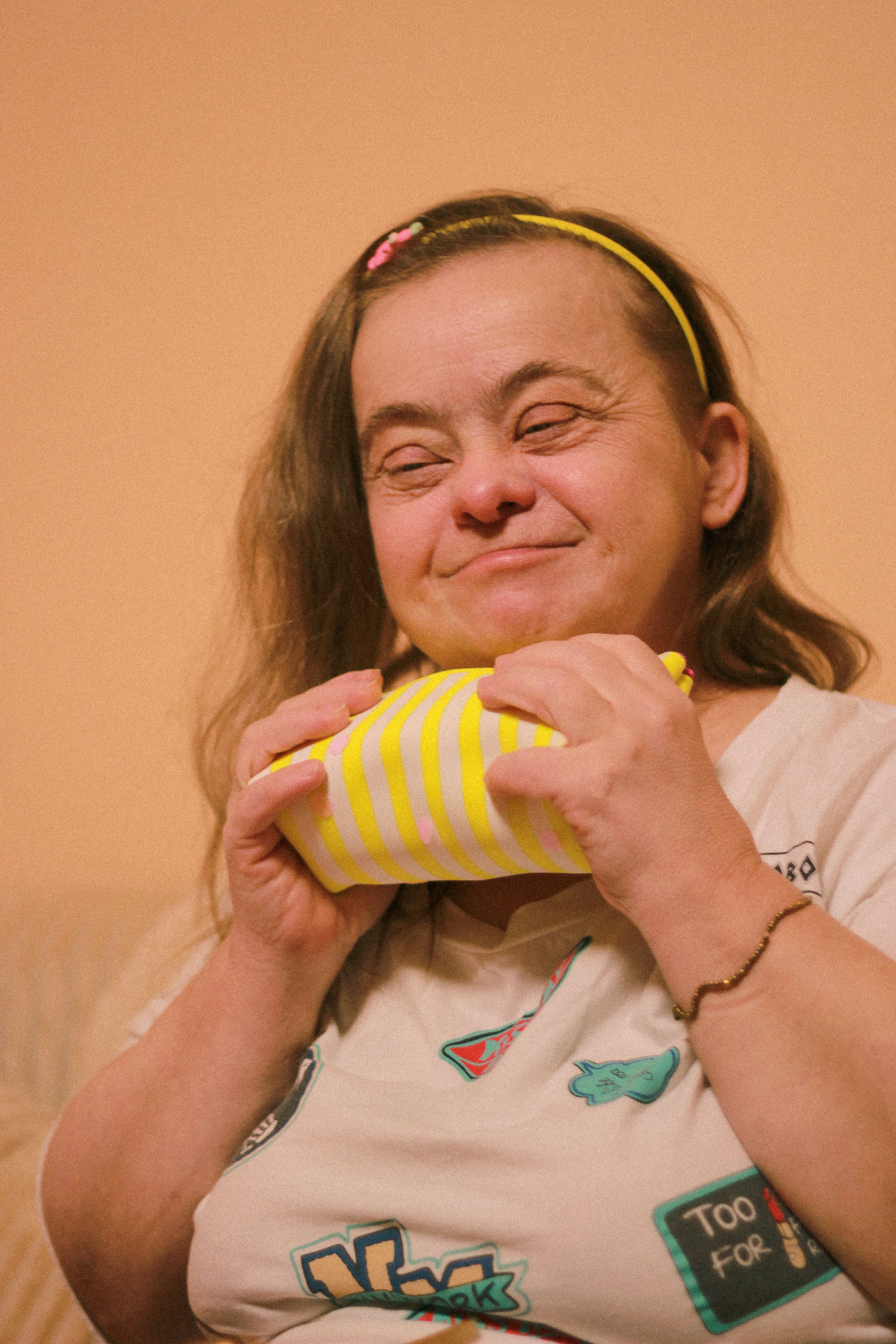 A woman with Down syndrome beaming with joy while holding a gift