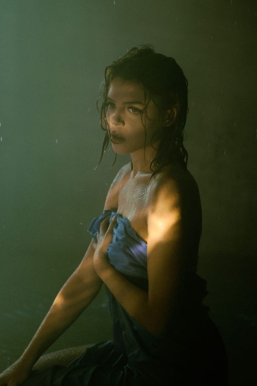 Free Moody portrait of a woman with wet hair wrapped in a towel, highlighted by dramatic lighting. Stock Photo