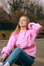 Portrait of Blond Haired Woman in Pink Sweatshirt Sitting