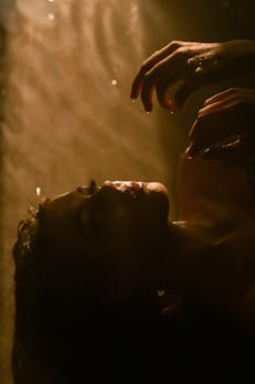 Mystical and dramatic portrait of a woman submerged in dimly lit water.