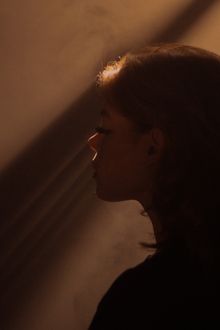 Side profile portrait of a woman in dramatic lighting, photo by Daria on Pexels