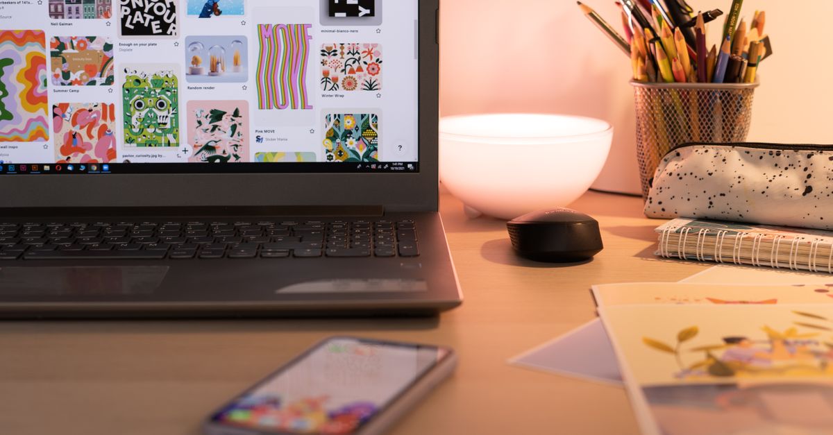 A cozy desk setup with art supplies, laptop, and smartphone, ideal for creative work in Bucharest.