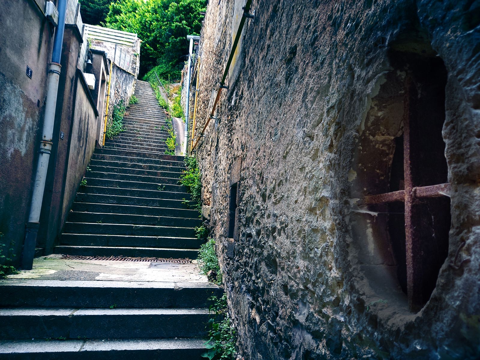 Escalier de pierre raide dans une ruelle étroite le long d'un vieux mur