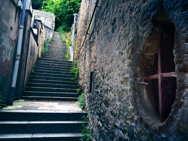 Escalier de pierre raide dans une ruelle étroite le long d'un vieux mur
