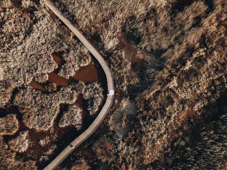 Drone shot of a wooden pathway weaving through a marshland near Valencia, Spain.