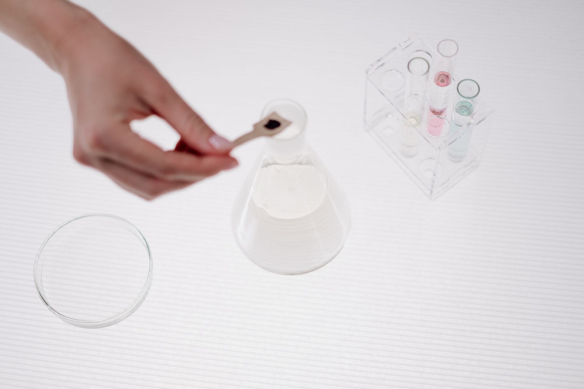 Close-up of a person handling a beaker in a science lab setting.