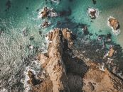 Aerial View of Brown Rocky Mountain Beside Body of Water