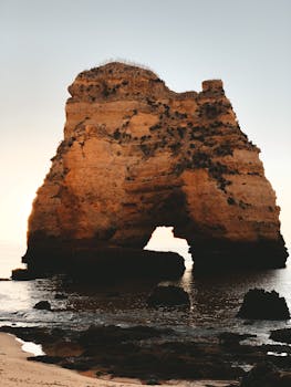 Stunning view of Algarve's iconic rock formation at sunset showcasing natural beauty.