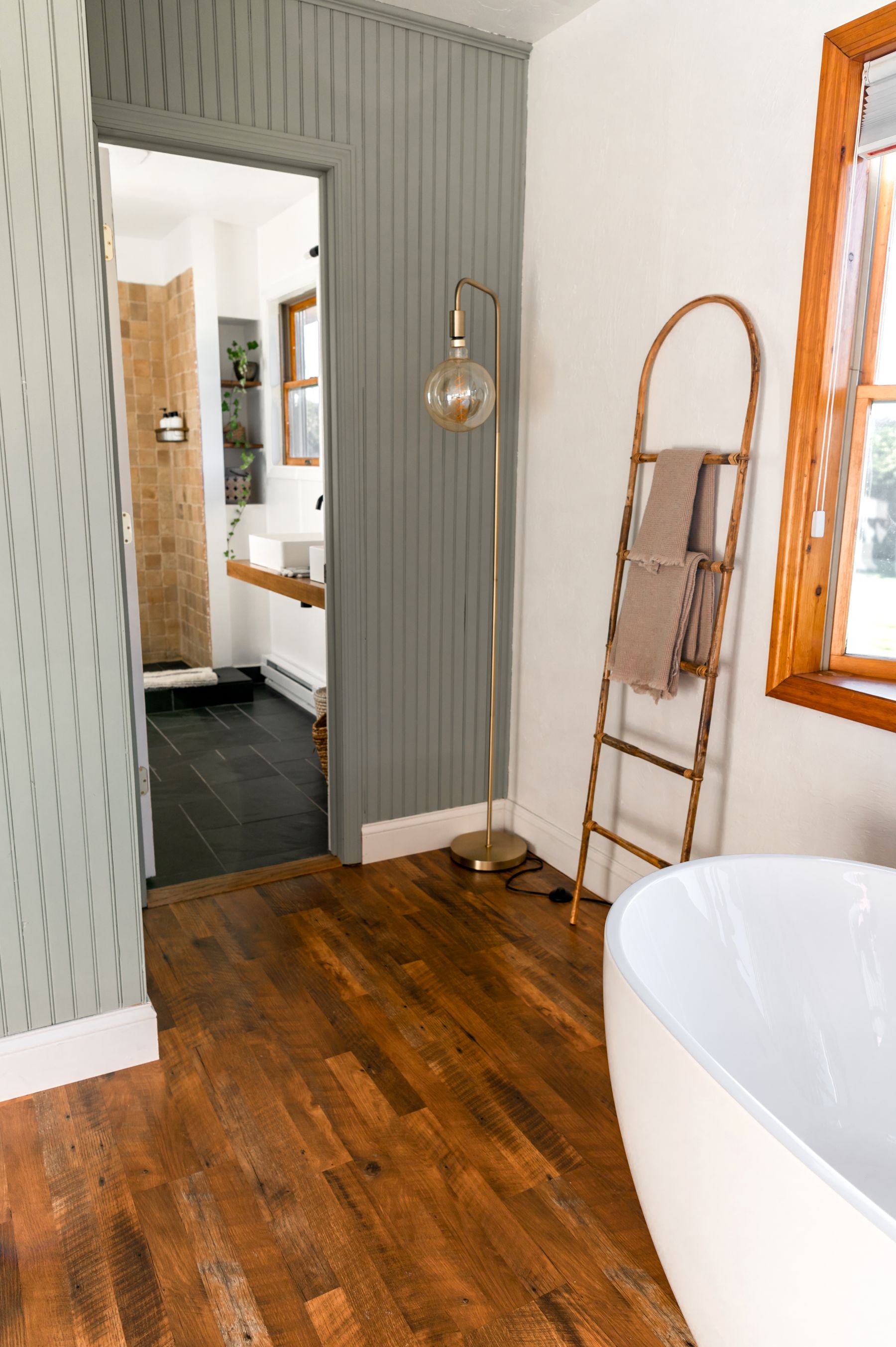Calm bathroom with warm wood flooring and neutral finishes