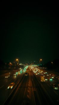 A bustling highway with dense nighttime traffic captured from above, showcasing city life and transportation.