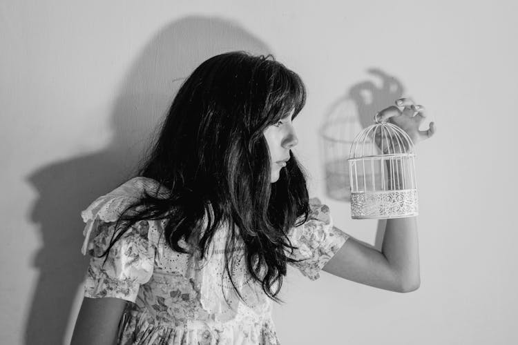 Grayscale Photo Of Woman Holding A Birdcage