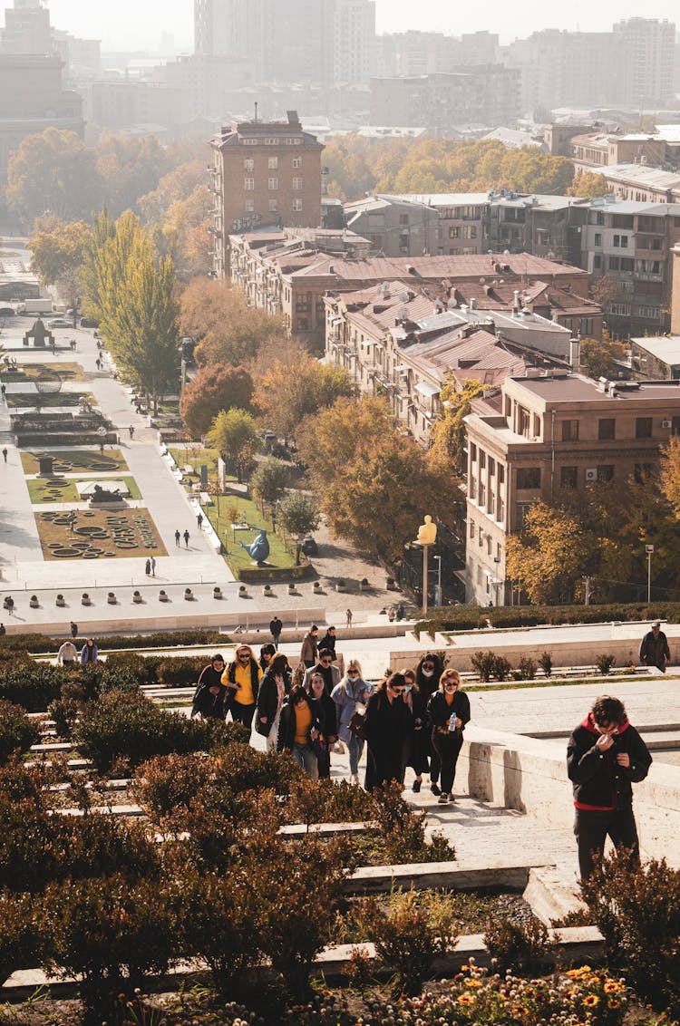 People Walking Uphill In City