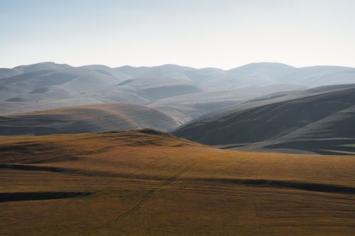 Free Peaceful mountain view with rolling hills and clear sky, perfect for travel inspiration. Stock Photo
