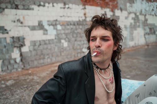 A Man in Leather Coat Smoking Cigarette