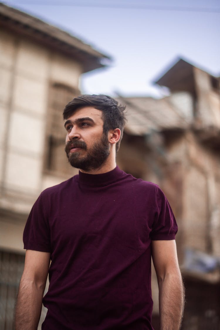 A Low Angle Shot Of A Bearded Man Wearing A Turtle Neck Shirt