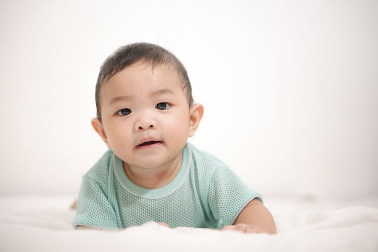 Baby Boy Laying On Stomach Looking At Camera