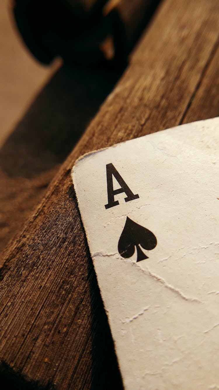 An Ace Of Spade On A Wooden Table Top