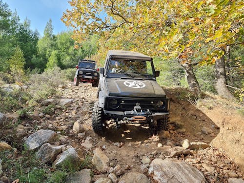 Two Cars Moving on a Dirt Road