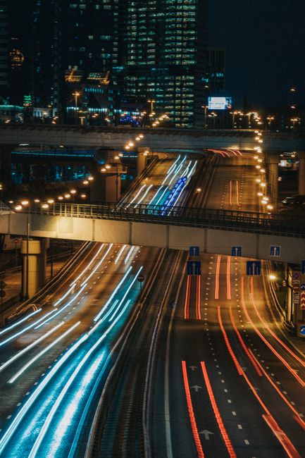 Long exposure shot of city highway with vibrant light trails of vehicles at night.