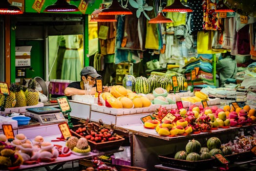 Colorful fruit market stall in Hong Kong with vendor, showcasing tropical produce.