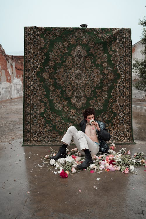 A Man Sitting on the Ground with Scattered Flowers