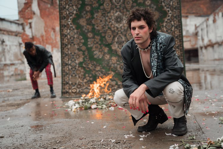 Man In Black Overcoat And White Pants Sitting 