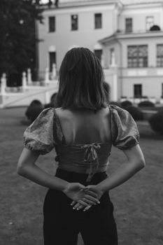 Black and white portrait of a woman standing outside a classic building in Los Angeles.