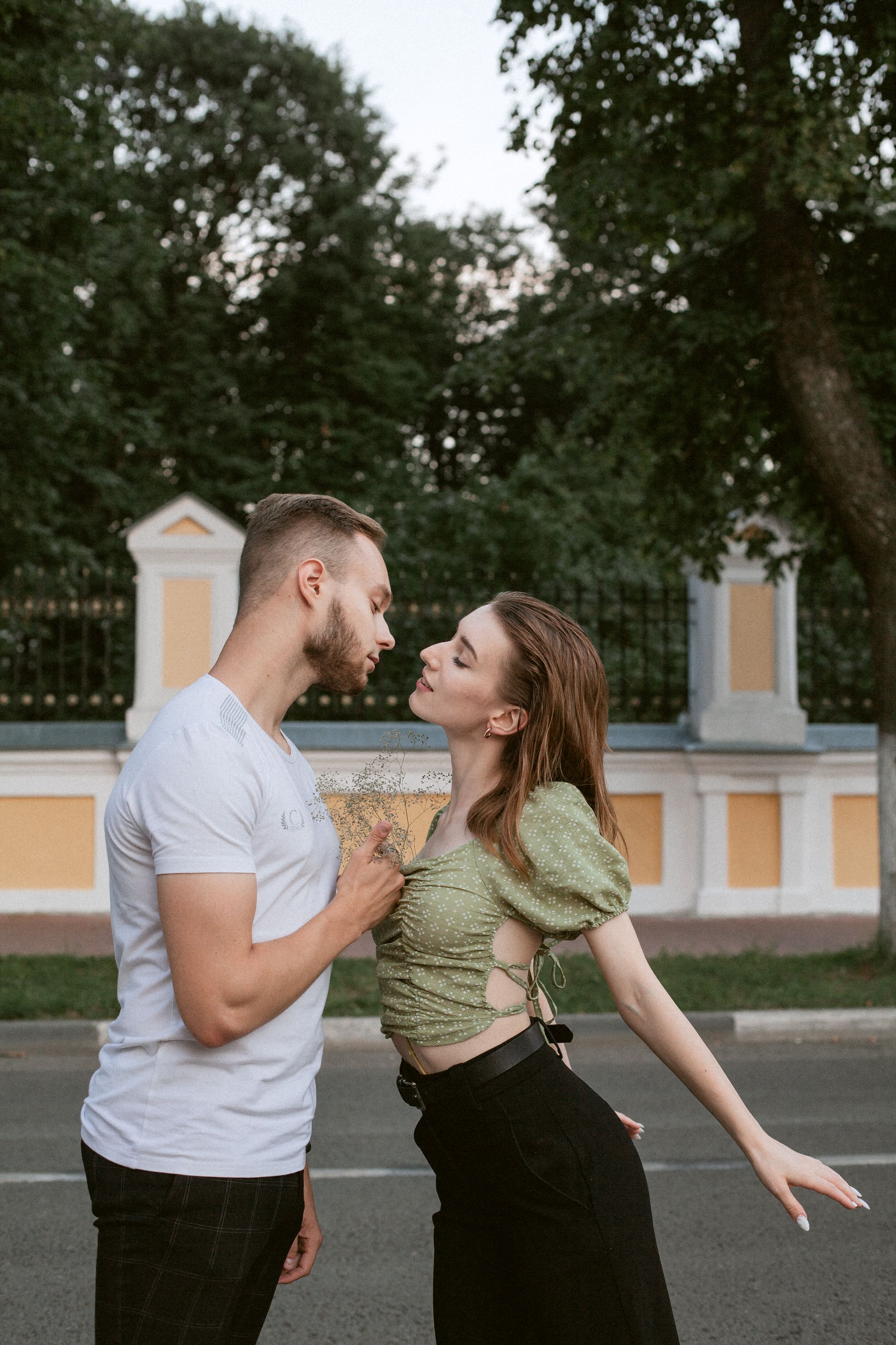 Young couple lovingly interacting outdoors in summer.