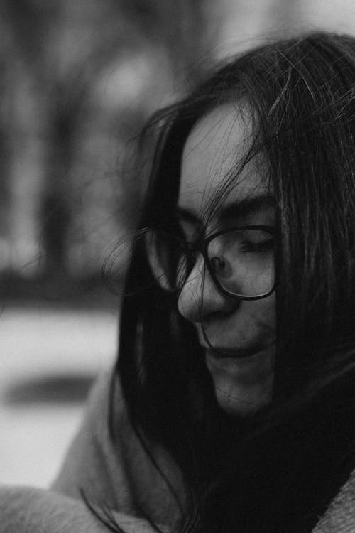 A Grayscale Photo of a Woman Wearing Eyeglasses