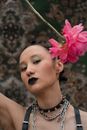 Woman in Black and White Sleeveless Top Holding Pink Flower
