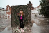 Woman in Black Jacket Standing Beside Brown and Beige Wall