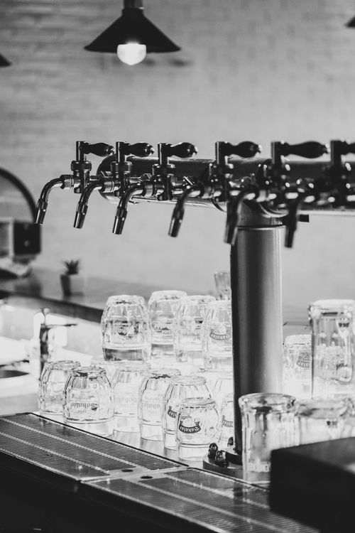 Free Monochrome image of beer taps and glasses on a bar counter. Stock Photo