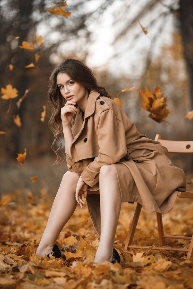 Attractive Young Woman With Long Brown Hair Sitting On Bench In Park