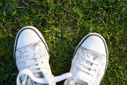 Free Pair of White Lace-up Sneakers on Top Green Grass Stock Photo