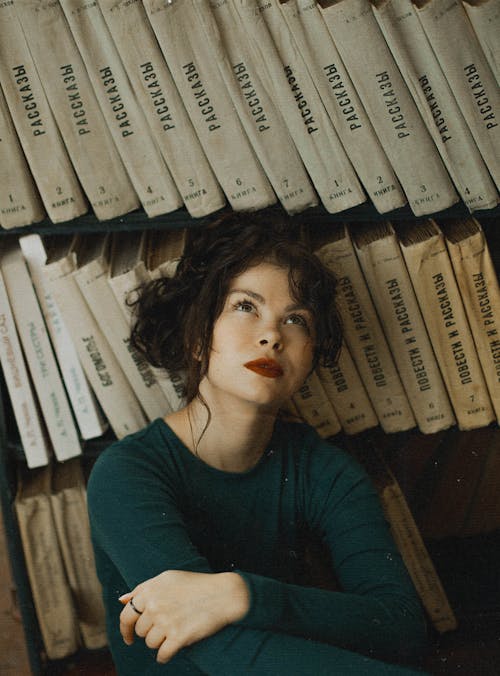 Woman Leaning on Book Shelf 