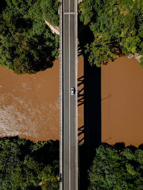 A Car on a Concrete Bridge Over a Body of Water