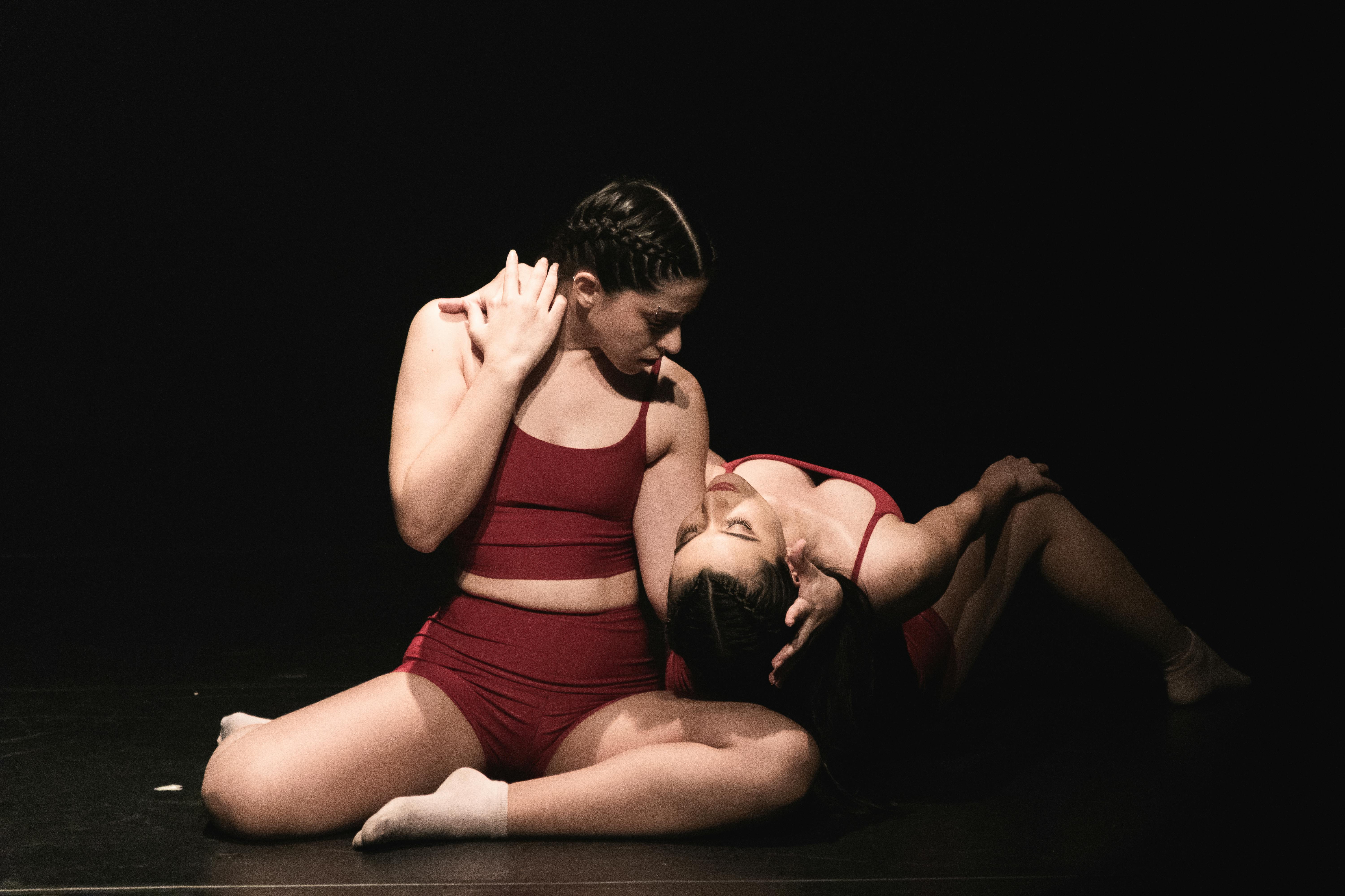 Free Two women in red sportwear performing contemporary dance on stage. Stock Photo