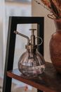 Plant Mister with Water on Shelf next to Flower Vase