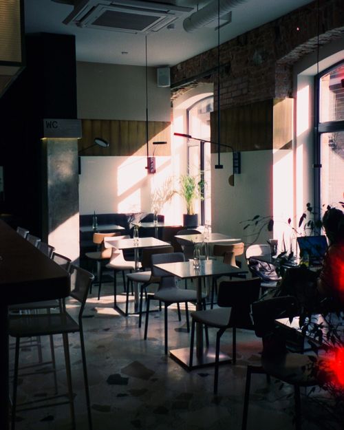 Free Warm ambiance of a sunlit café in Saint Petersburg with empty chairs and tables. Stock Photo