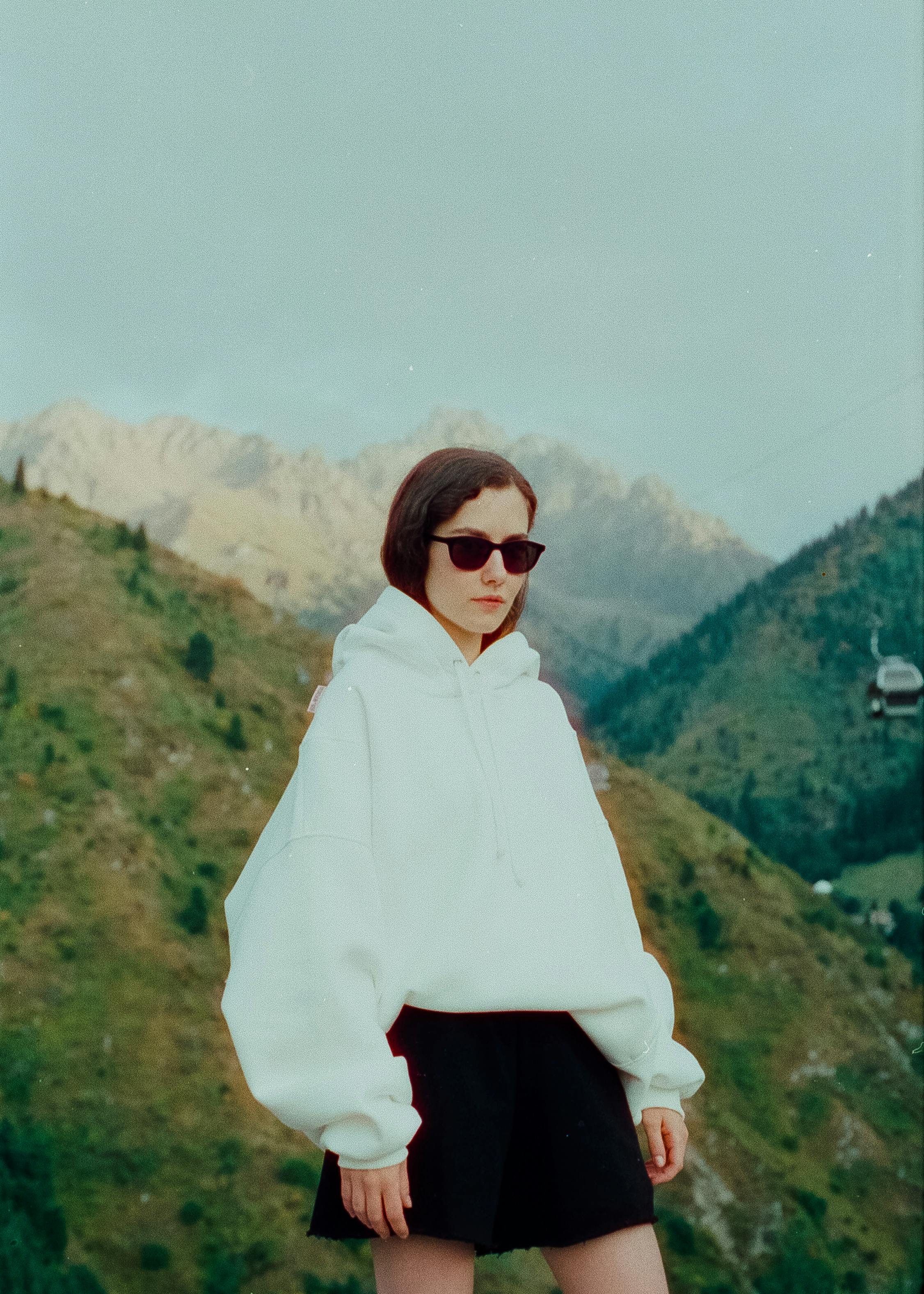 teenage girl wearing short skirt and blouse in mountains