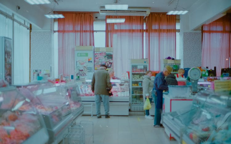 Small Group Of People Doing Shopping In Local Store