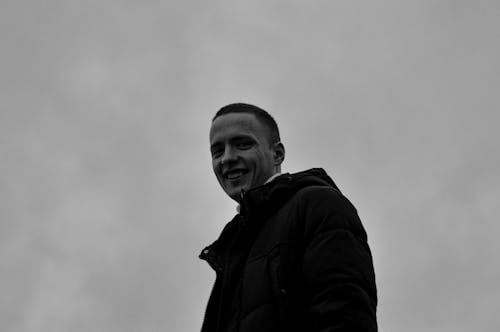 A Grayscale Photo of a Man in Black Jacket